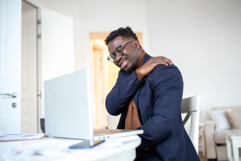tired african businessman working from home his computer feeling pain his shoulder 1536x1024 1 768x512